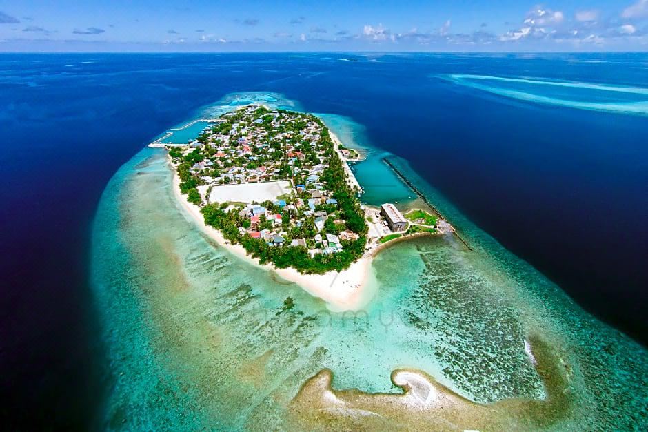 a bird 's eye view of a small island with a beach and buildings in the middle at Liberty Guesthouse Maldives