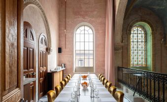 a long dining table set for a meal , with wine glasses and a vase of flowers on the table at The Jaffa, a Luxury Collection Hotel, Tel Aviv