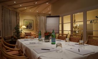 a conference room set up for a meeting , with several tables and chairs arranged for attendees at Hotel Sailer