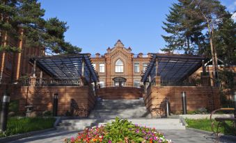 a brick building with stairs leading up to it and flowers in front of the entrance at Parus
