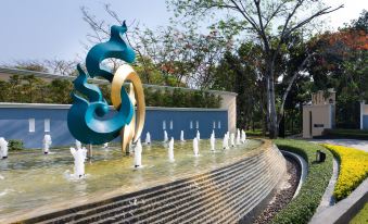 a large fountain with a blue and gold design is surrounded by white statues on a stone ledge at RK Riverside Resort & Spa (Reon Kruewal)
