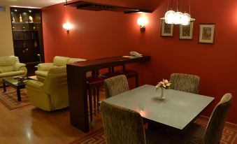 a dining room with a table and chairs , as well as a living area with a couch and a bar at Monteverde Hotel