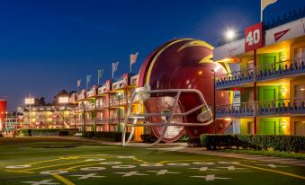 a large , colorful building with a football helmet on top and the number 4 on top at Disney's All-Star Sports Resort