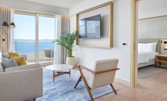 a modern living room with a large window overlooking the ocean , featuring beige furniture and wooden flooring at Le Meridien Lav Split