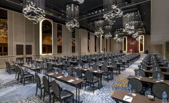 A spacious room is arranged with tables and chairs for hosting events at the hotel or conference at Sofitel Saigon Plaza