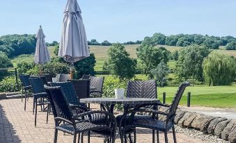 a patio area with a table and chairs , an umbrella , and a view of the outdoors at Horsley Lodge