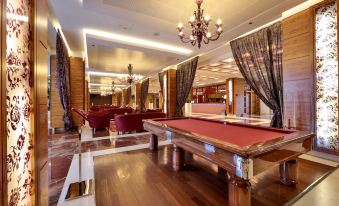 a large room with a pool table , multiple couches , and chairs arranged around them , creating a comfortable and inviting atmosphere at Unahotels Expo Fiera Milano