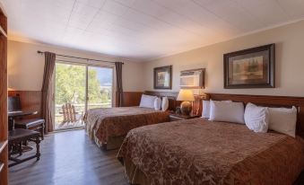 a hotel room with two beds , one on each side of the room , and a television mounted on the wall at Yellowstone Valley Lodge, Ascend Hotel Collection