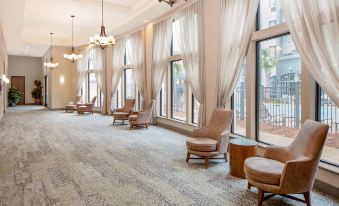 a large room with multiple chairs and couches arranged in rows , creating a comfortable seating area at Courtyard Houma