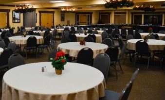 a large dining hall with multiple round tables , each set for a meal , and a floral centerpiece on each table at Daniels Summit Lodge