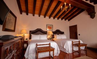 a hotel room with two beds , one on the left and one on the right side of the room at Las Mananitas Hotel Garden Restaurant and Spa