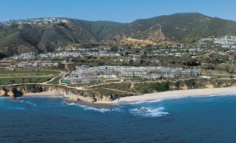 aerial view of a coastal town surrounded by mountains , with a beach visible in the distance at Montage Laguna Beach