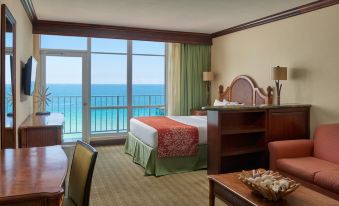 a hotel room with two beds , a desk , and a large window overlooking the ocean at Newport Beachside Hotel & Resort
