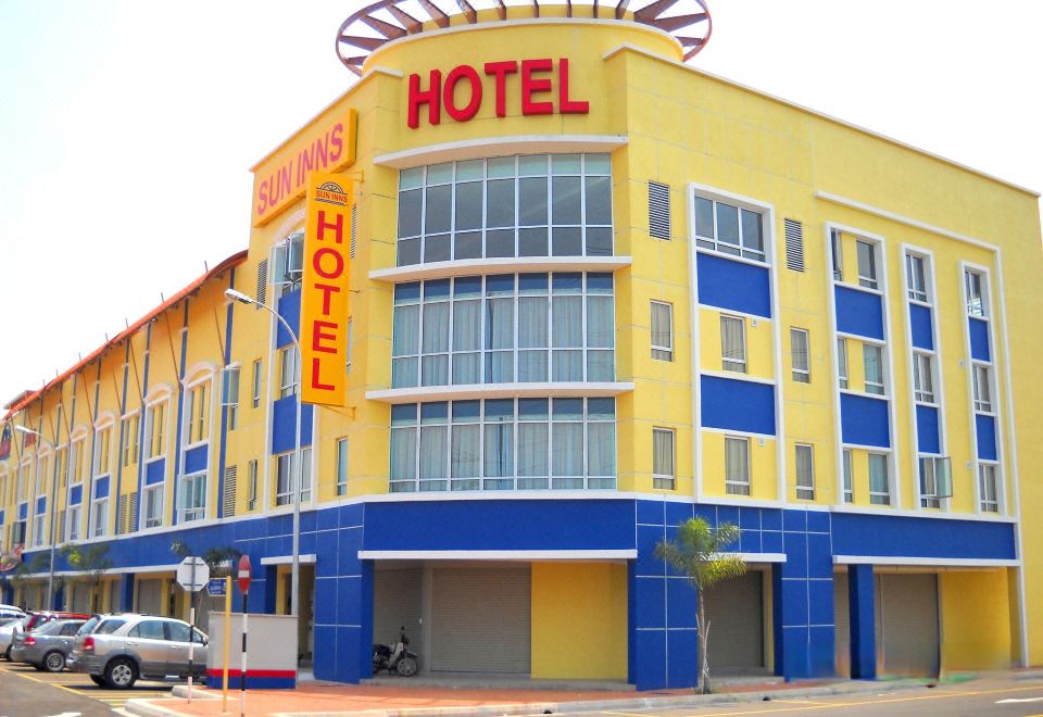 "a brightly colored hotel building with the name "" flavors hotel "" prominently displayed on the front" at Sun Inns Hotel Kuala Selangor