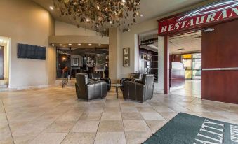 "a lobby area with two couches , a chandelier , and a sign for "" r ' estart "" on the wall" at Quality Inn & Suites Bay Front