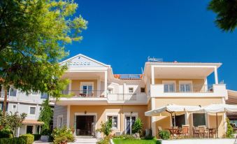 a large house with a balcony and outdoor seating area is surrounded by trees and grass at G George