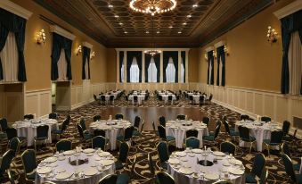 a large , empty banquet hall with round tables and chairs is set up for a formal event at Gettysburg Hotel