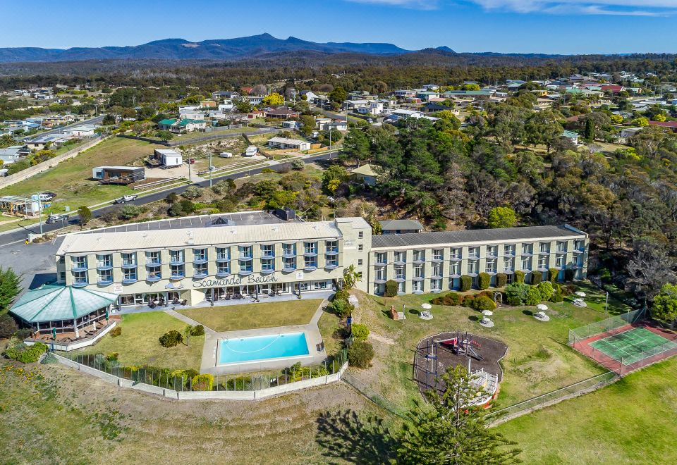 an aerial view of a large building with a pool and surrounding greenery , surrounded by mountains at Scamander Beach Resort