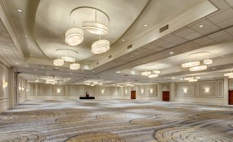 a large , empty banquet hall with high ceilings and multiple circular lights hanging from the ceiling at Hilton Albany