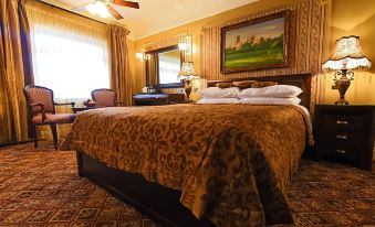 a luxurious bedroom with a large bed , wooden furniture , and a painting on the wall at Riverside Inn