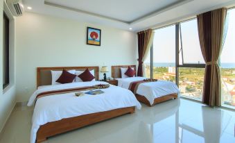 a modern bedroom with two beds , white bedding , and large windows offering views of the city at Amanda Hotel