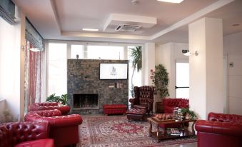 a large room with a stone fireplace , red couches , and a flat - screen tv mounted on the wall at Hotel Palace