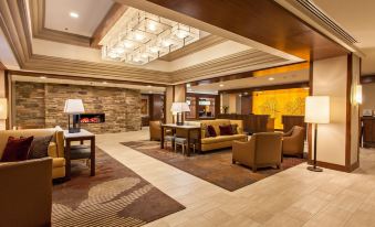 a spacious , well - lit hotel lobby with comfortable seating arrangements and a fireplace , providing a pleasant atmosphere for guests at DoubleTree by Hilton Hotel Pittsburgh - Green Tree