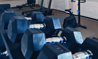 a well - equipped gym with various exercise equipment , including dumbbells and an elliptical machine , on the floor at Strawberry Park Resort