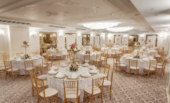 a large , elegant banquet hall filled with round tables and chairs , ready for a formal event at DoubleTree by Hilton Gaziantep