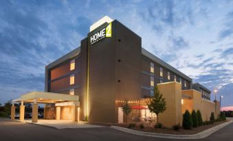"a large hotel building with the name "" home 2 "" prominently displayed on its front , illuminated at night" at Home2 Suites by Hilton Milwaukee Brookfield