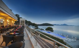 a luxurious hotel with a balcony overlooking the ocean , offering a stunning view of the sunset at Vitality Hotel Punta