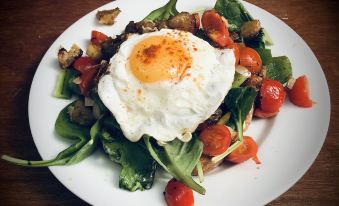 a plate of food on a dining table , consisting of a salad and an egg at Breakers