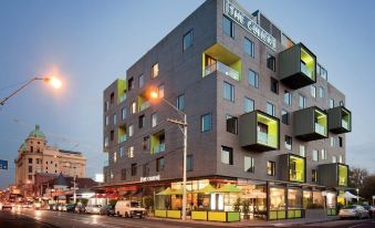 "a modern building with a yellow facade and the word "" the terrace "" on it is lit up at night" at The Cullen Melbourne - Art Series