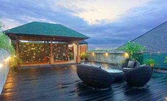 a rooftop with a pool and two lounge chairs , one of which has a unique design at Kautaman Hotel