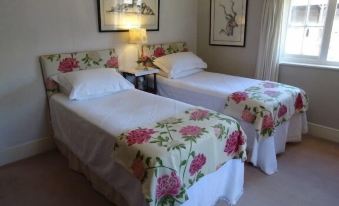 a room with two twin beds , one on the left side and the other on the right side of the room at Moor Court Farm