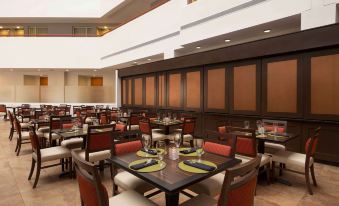 a large dining room with multiple tables and chairs arranged for a group of people to enjoy a meal together at Embassy Suites by Hilton Baltimore at BWI Airport