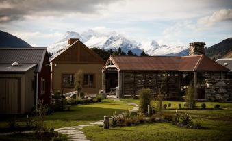 a picturesque rural setting with wooden houses surrounded by lush greenery , and a mountain range in the background at The Headwaters Eco Lodge
