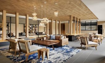 a modern living room with wooden ceiling , blue rug , and furniture arranged in a minimalist style at Fairfield by Marriott Tochigi Utsunomiya