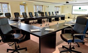 a large conference room with multiple chairs arranged in rows , and a long table in the center at BrookLodge & Macreddin Village