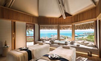 a room with two massage tables , one on the left and one on the right , both covered with white sheets at Conrad Bora Bora Nui