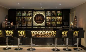 a well - decorated bar with several chairs and tables , creating an inviting atmosphere for patrons to enjoy drinks and socialize at DoubleTree by Hilton Gaziantep