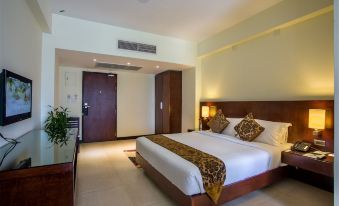 a large bed with a wooden headboard and white linens is in the middle of a room at Hotel Grand Park Barishal