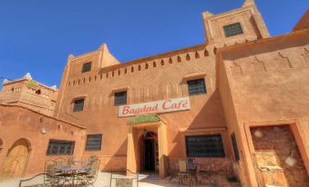 "the exterior of a building with a sign that says "" bagdad cafe "" and several tables outside" at Bagdad Cafe
