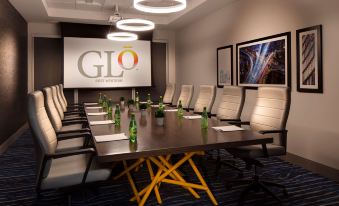 a conference room with a long table , chairs , and a projector displaying the glo logo at GLo Best Western Kanata Ottawa West