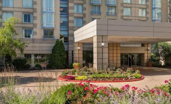 a large building with a flower garden in front of it , creating a beautiful and inviting atmosphere at Sheraton Suites Chicago Elk Grove