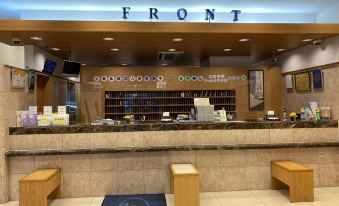 "a counter with a sign that says "" front "" and a small group of people sitting at the counter" at Toyoko Inn Oita Ekimae