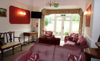 a living room with a couch , chairs , and a television in front of a door at Oakhill