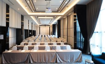 a large conference room with rows of chairs and tables , all covered in white tablecloths at Fortune Saeng Chan Beach Hotel Rayong