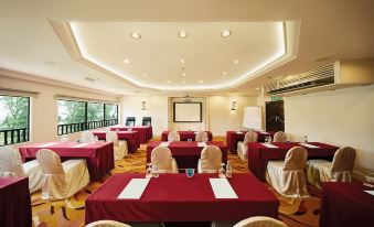 a conference room set up for a meeting , with multiple tables and chairs arranged in rows at Resorts World Kijal