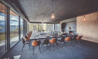 a large conference room with a long table and chairs arranged for a meeting , surrounded by windows and a view of the city at Spaces Hotel